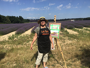 Woman in front of an easel and lavender fields during Walk the Arts art workshops in Provence France
