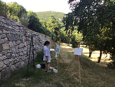 Woman in front of an easel with painting during Walk the Arts art workshops in Provence and painting holidays in France