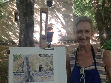 Woman artist in front of her oil painting during Walk the Arts painting workshop in Provence