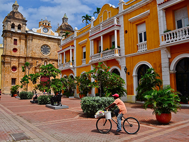 Man on a bike in a square in Cartagena during Walk the Arts winter escape and art workshop in South America