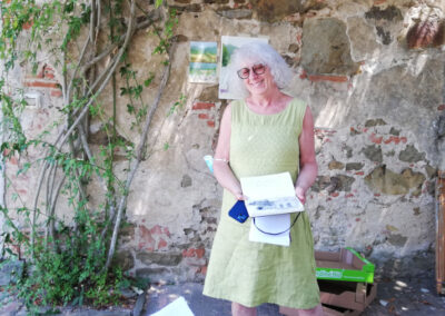 Woman showing a painting during Walk the Arts art workshop in Italy