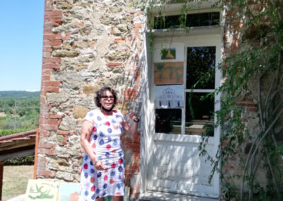 Woman in front of her paintings during a plein air art workshop in Italy