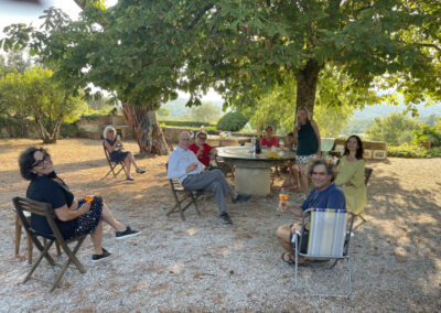 A group of artists in a garden taking a Spritz during an art retreat in Italy by Walk the Arts