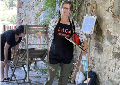 Woman with an easel and paint attending an art workshop in Italy by Walk the Arts