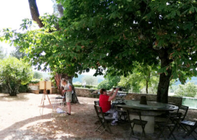 Two women in a garden getting ready to paint during Studio Italia, a unique art workshop in Tuscany