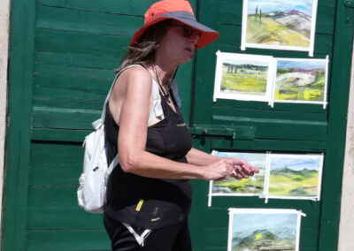 Artist Christine Monhollen in front of her paintings during an art retreat in Italy offered by Walk the Arts