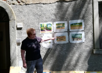 Artist Kathleen Gross showing her paintings during an art workshop in Tuscany by Walk the Arts